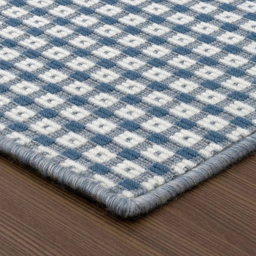 Blue and white checkered rug on a wooden floor